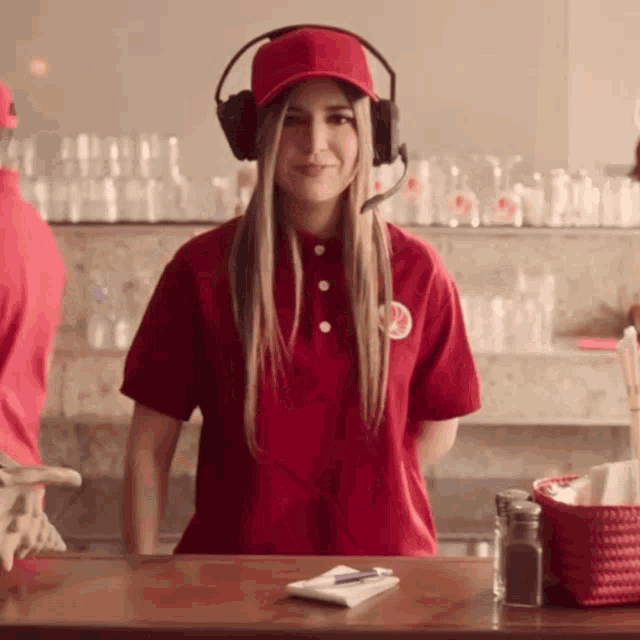 a woman wearing headphones and a red shirt with a circle on the front