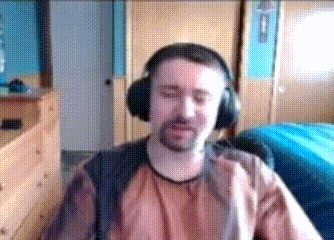 a man wearing headphones is sitting in front of a blue bed