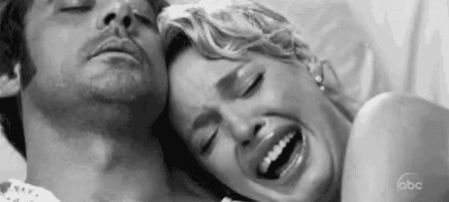 a black and white photo of a man and a woman laying next to each other .