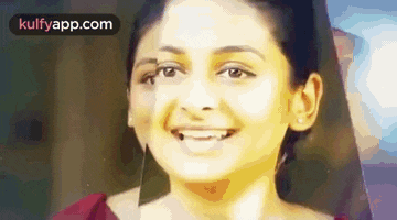 a woman is smiling and looking at the camera .