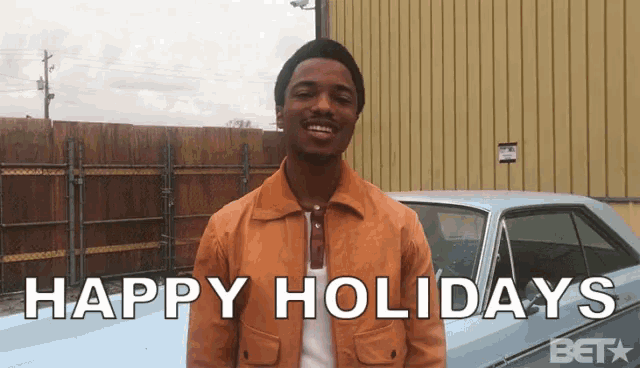 a man standing in front of a car with the words happy holidays below him