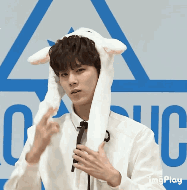 a man wearing a white hat with bunny ears is standing in front of a sign that says onic