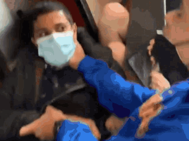a man wearing a mask and a blue shirt