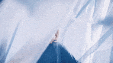a woman with blonde hair is wearing a blue shirt and looking up at the sky .