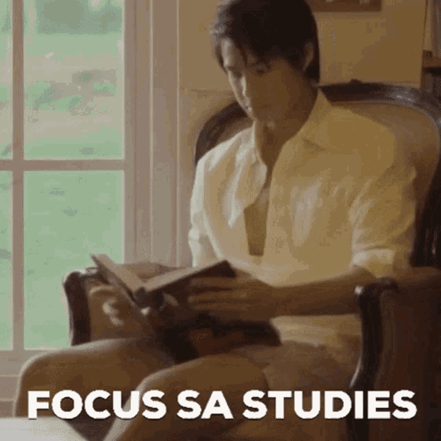 a man is sitting in a chair reading a book with the words focus sa studies written below him