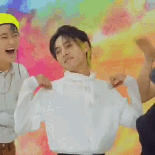 a group of young men are standing next to each other in front of a colorful wall .