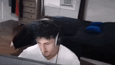 a man wearing headphones is sitting at a desk in front of a computer .