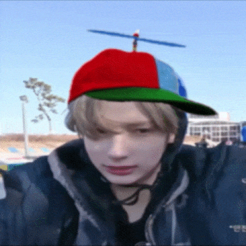 a young man wearing a hat with a propeller on it .