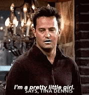 a man is standing in front of a chandelier and says `` i 'm a pretty little girl , '' .