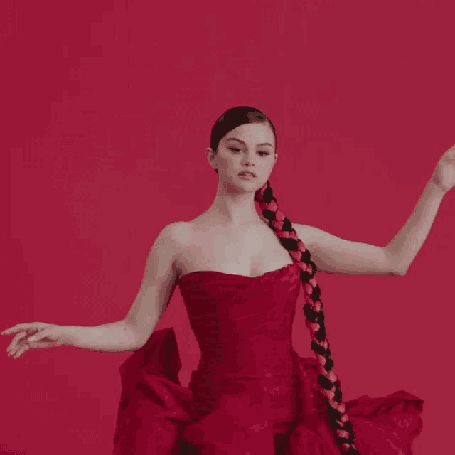 a woman in a red dress with a braid in her hair .