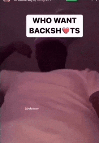 a man in a white shirt is making a heart shape with his hands and the words " who want backshots " above him