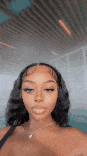 a woman is wearing a necklace and taking a selfie .
