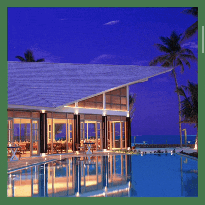 a large building with a swimming pool in front of it at night