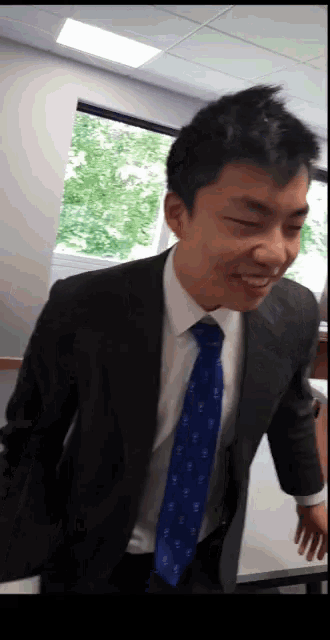 a man wearing a suit and tie is smiling