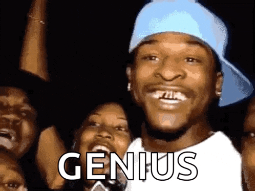 a man in a blue hat is smiling in front of a crowd with the word genius written on his face