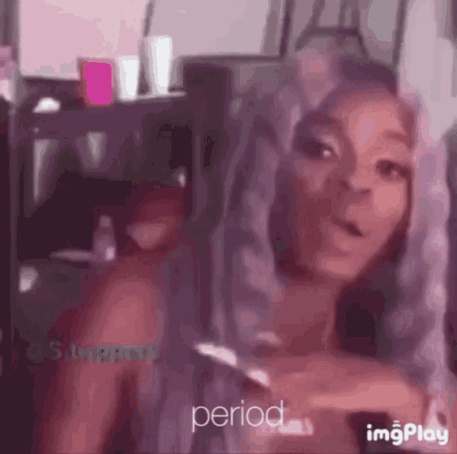 a woman with purple hair is smoking a cigarette and the word period is on the bottom of the screen