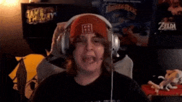 a woman wearing headphones and a red hat is sitting in a gaming chair .