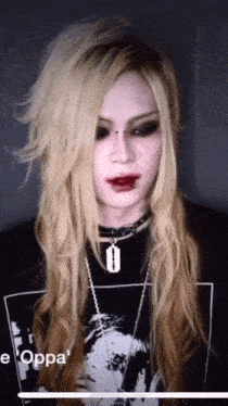 a woman with long blonde hair is wearing a black shirt that says e oppa
