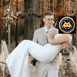 a man in a suit is carrying a woman in his arms