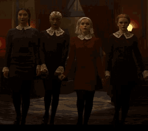 a group of women are walking in a dark room