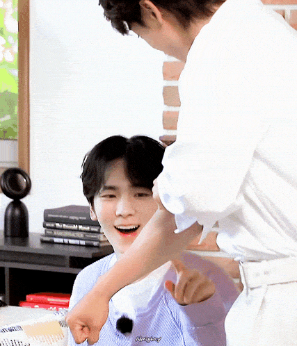 a man in a white shirt is putting his fist on another man 's shoulder