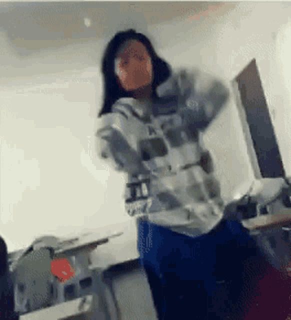 a woman is standing in a room with a hoodie that says ' a ' on it