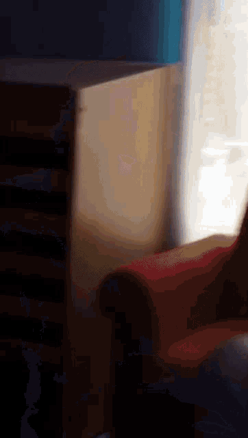 a red chair sits in front of a window