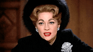 a close up of a woman wearing a black hat and earrings