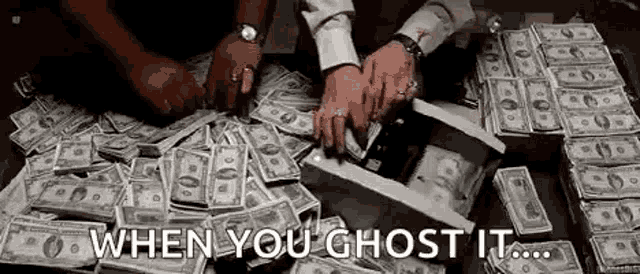 a pile of money is being stacked on top of each other on a table with a man holding a box of money .
