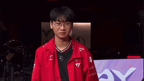 a man wearing glasses and a red shirt with mercedes on it