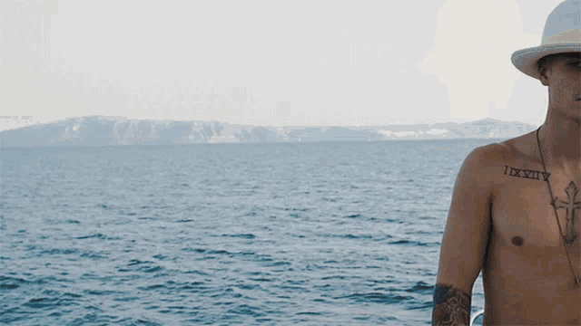 a man without a shirt has a tattoo on his chest that says ixxiv