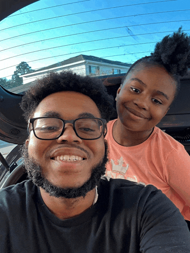 a man and a girl are posing for a picture in a car