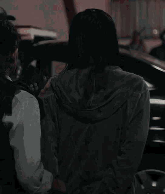 a woman is standing in front of a car that has the number 18 on it