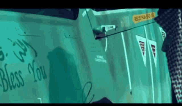 a green vehicle with the words " bless you " written on the side