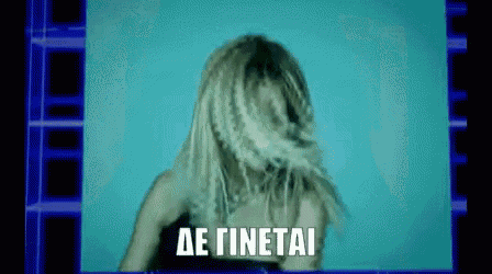 a woman with blonde hair is dancing in front of a screen that says ' de tinetai '