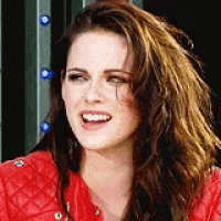 a close up of a woman wearing a red jacket smiling