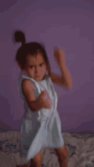 a blurry picture of a girl in a blue dress jumping on a bed