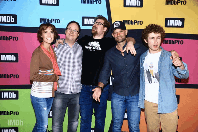a group of people are posing for a photo in front of a wall that says imdbpro