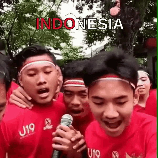 a group of young men singing into a microphone with the word indonesia written on the bottom