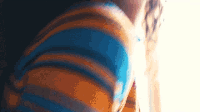 a close up of a person 's arm with a blue and orange striped shirt