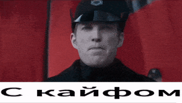a man in a military uniform is standing in front of a red curtain and a sign that says " c kaipom "