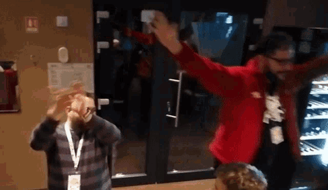 a man in a red jacket has a lanyard around his neck with a name tag that says ' stefan ' on it