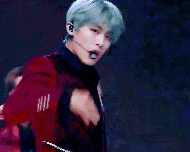 a man wearing a microphone and a red jacket is dancing
