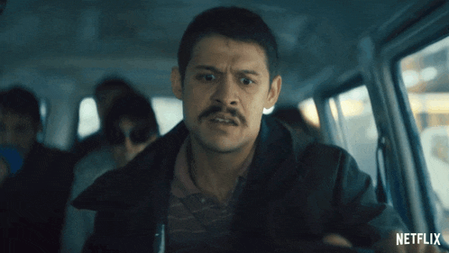 a man with a mustache is sitting in a bus with netflix written on the bottom