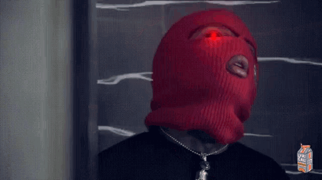 a person wearing a red ski mask with a skeleton sticker on it .