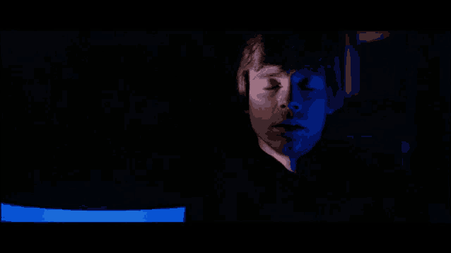 a close up of a man 's face in a dark room