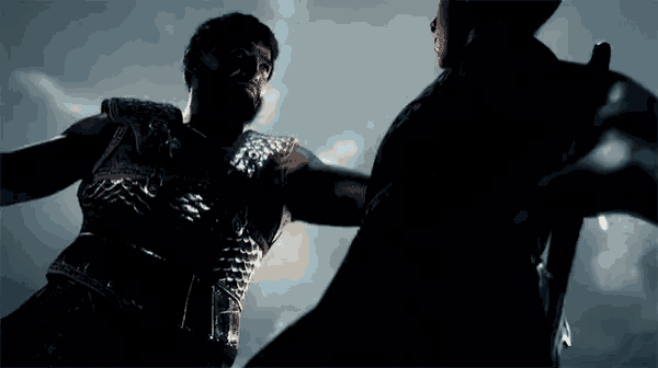 a man with a beard is holding another man 's arm
