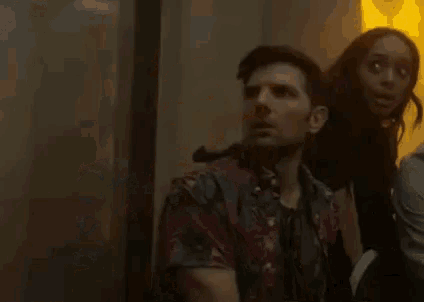 a man and a woman are standing next to each other in a room with smoke coming out of the walls .