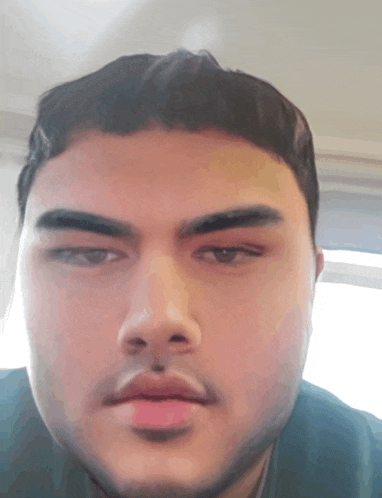 a man with a beard looks at the camera with a serious look on his face