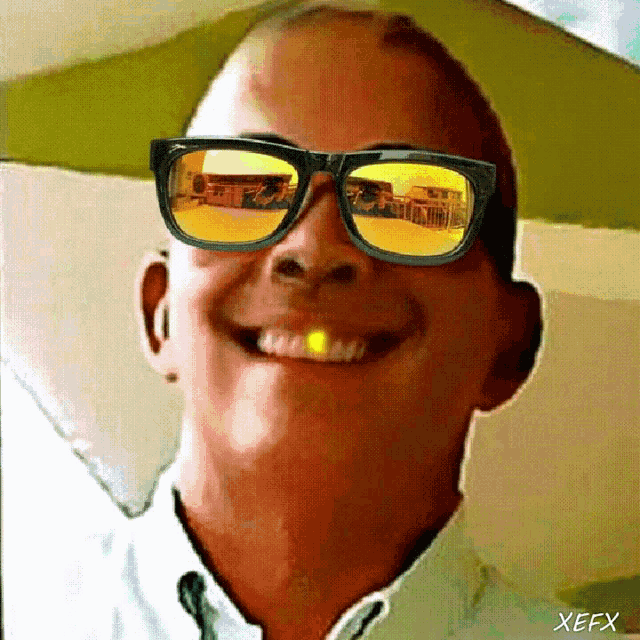 a close up of a man wearing sunglasses with the letters xefx on the bottom right